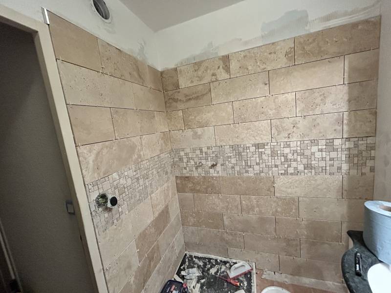 Pose du carrelage travertin avant les finitions de la douche à Orange Vaucluse 
